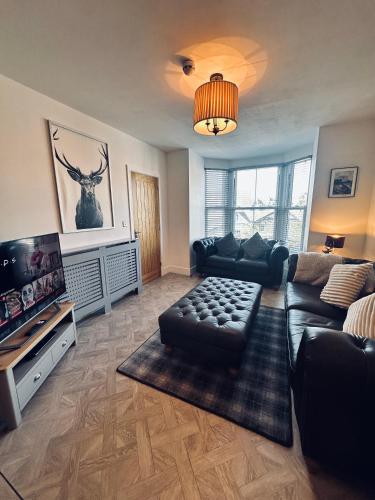 a living room with a couch and a flat screen tv at Luxury Pet Friendly 3 Bedroom Home with Copper Bath in Bowness-on-Windermere