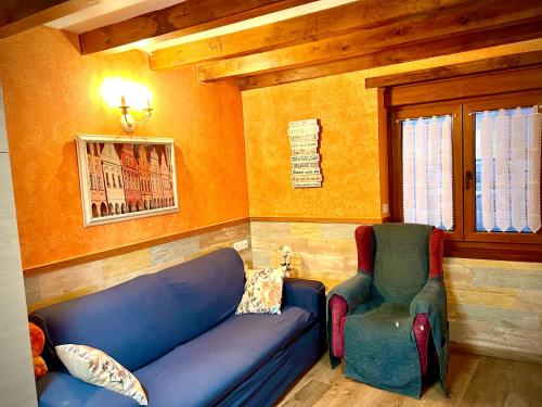 a living room with a blue couch and a chair at Viviendas Rurales El Cantón in Cucayo