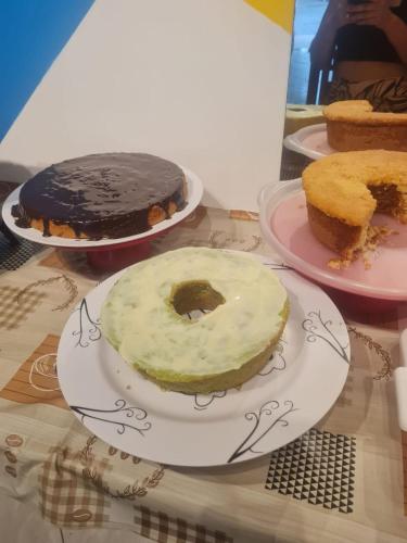 a table with three different types of cakes on plates at Pousada Panceiro in Cabo Frio