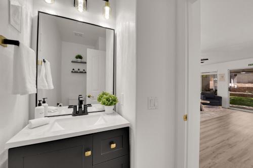 une salle de bain avec un lavabo et un miroir dans l'établissement Heart of Henderson, à Las Vegas