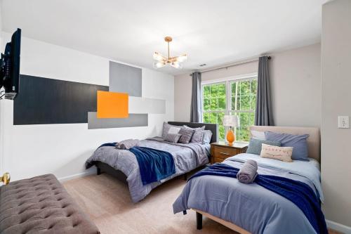 a bedroom with two beds and a window at Cozy 2BR Retreat with BBQ, WIFI & Parking in Raleigh