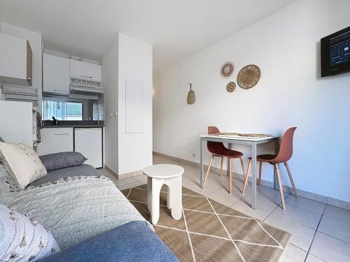 un salon avec un canapé et une table avec des chaises dans l'établissement Studio calme avec balcon proche du port de Nice, à Nice