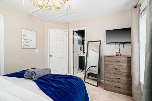 a bedroom with a bed and a television and a dresser at Cozy 2BR Retreat with BBQ, WIFI & Parking in Raleigh