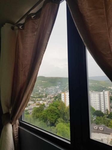 a window with a view of a city at 1BR - 17th fr Mountain-view at Sundance Residences in Cebu City