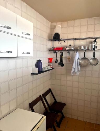 a kitchen with white cabinets and a table and chairs at Apartamento Vista-Mar in Maceió