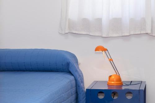 a blue bed with a lamp on a side table at Casa Ponente con Vista Mare a Macari in Macari