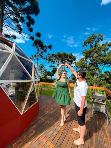 a man and a woman dancing on a deck at Cabanas Bela Vista in São Bento do Sapucaí