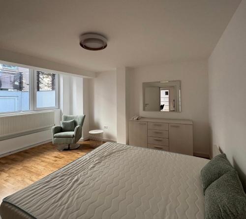 a bedroom with a bed and a chair and a mirror at Moon night in Niš