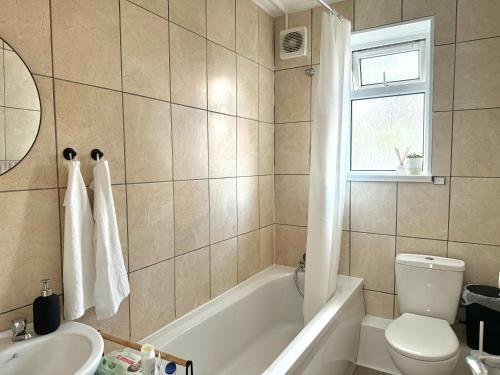 a bathroom with a tub and a toilet and a sink at Deducted 3B Flat, Fast Wi-Fi, 5 min Canning Town, near ExCel & O2 in London