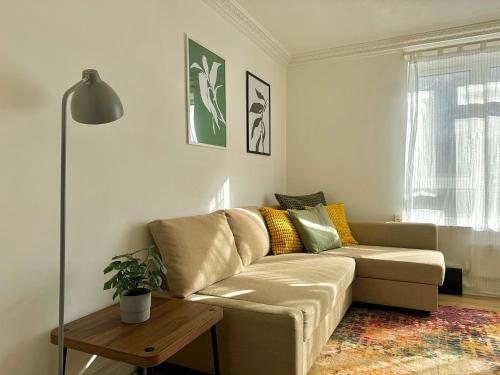 a living room with a couch and a table at Deducted 3B Flat, Fast Wi-Fi, 5 min Canning Town, near ExCel & O2 in London
