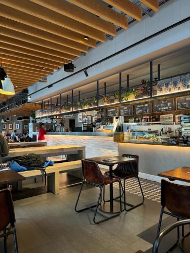 a restaurant with tables and chairs and a counter at Deducted 3B Flat, Fast Wi-Fi, 5 min Canning Town, near ExCel & O2 in London