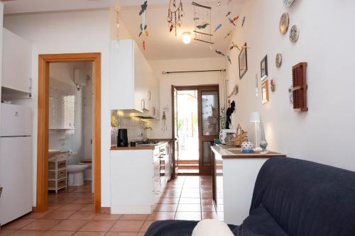 a kitchen and living room with white walls at Casa Ponente con Vista Mare a Macari in Macari
