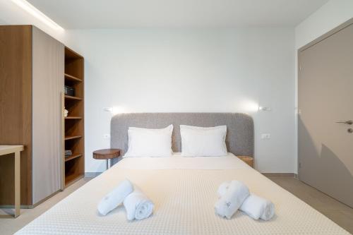 a bedroom with a white bed with two pillows at SuiteHome Villas with Private Pools by Explore Andros in Andros