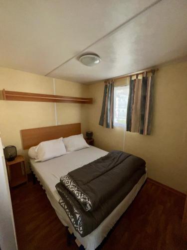 une chambre avec un lit et une fenêtre dans l'établissement Mobilhome Île d Oléron Camping Les Tamaris, à Saint-Pierre-dʼOléron