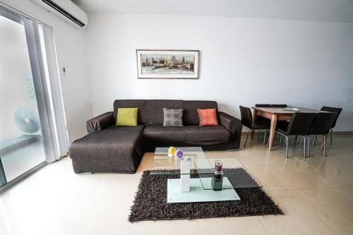 a living room with a couch and a table at Seaview flat in Mellieha's heart in Is-Sellum