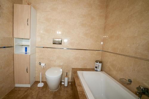 a bathroom with a bath tub and a toilet at Seaview flat in Mellieha's heart in Is-Sellum