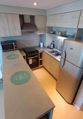 a small kitchen with a refrigerator and a sink at Departamento Mawaa in Colón