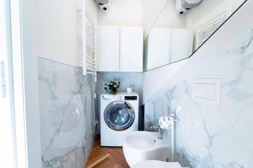 a bathroom with a washing machine and a toilet at BRERA LittleSuite DuomoView in Milan