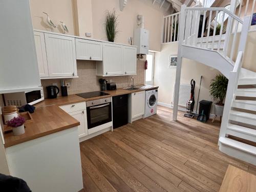 a kitchen with white cabinets and a staircase at Seaside Chapel Escape Character Home Near Beach Sleep 5 in Great Yarmouth