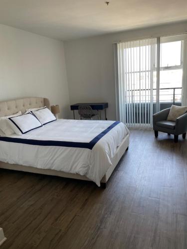 a bedroom with a large bed and a chair at Villa Marina - Luxe, Spacious, Gated, 2 Master Suites in TRUE Marina Del Rey in Los Angeles