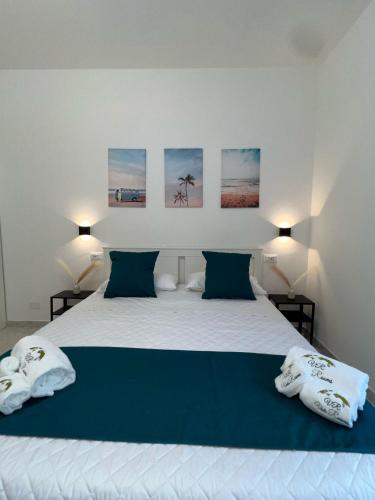 a bedroom with a large white bed with two pillows at Vida Rooms in Trapani