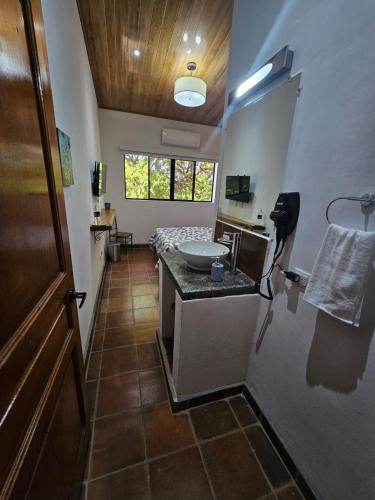 a bathroom with a sink and a bed in a room at Nica Valley in Rivas
