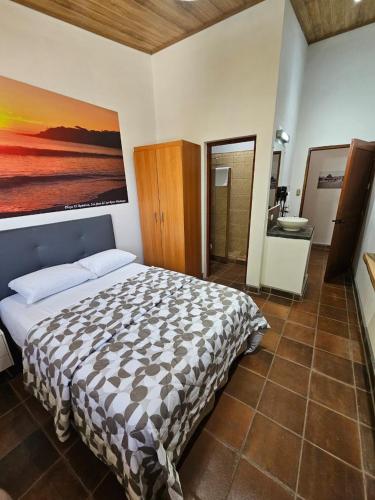 a bedroom with a bed with a painting on the wall at Nica Valley in Rivas