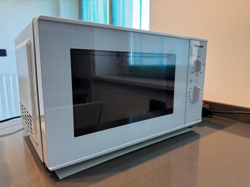 a microwave oven sitting on top of a table at Little Luxury Penthouse in Acilia