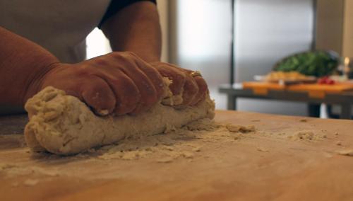 a person is kneading the dough on a table at Le Nicchie Guest House in Lucera