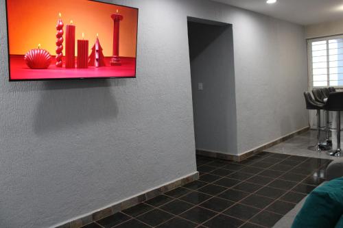 a waiting room with a tv on the wall at Comodo apartamento de 3 habitaciones, a 10 min en vehiculo del Zocalo de Oaxaca in Oaxaca City