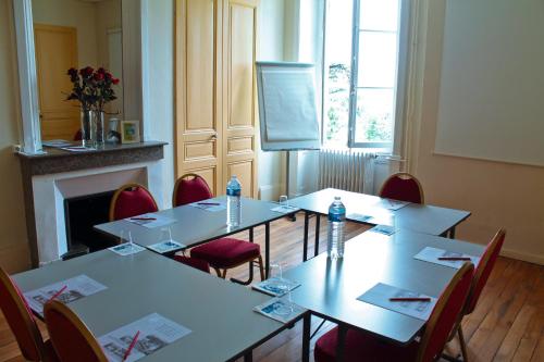a meeting room with tables and chairs and a screen at VTF Le Domaine Les Hautannes in Saint-Germain-au-Mont-dʼOr