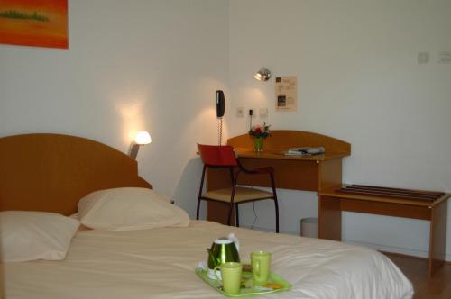 um quarto de hotel com uma cama e uma secretária em VTF Le Domaine Les Hautannes em Saint-Germain-au-Mont-dʼOr
