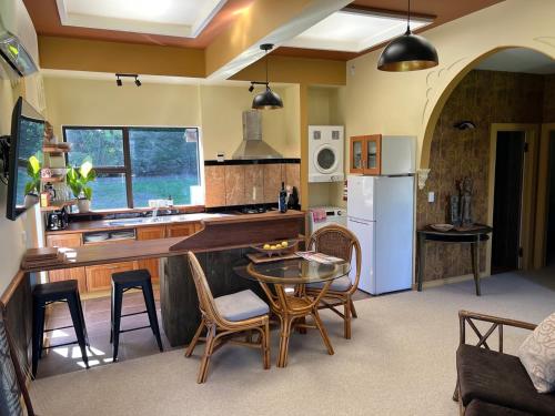 a kitchen with a table and chairs in a room at Greenwood Bungalow - Stylish Retreat in Otaki