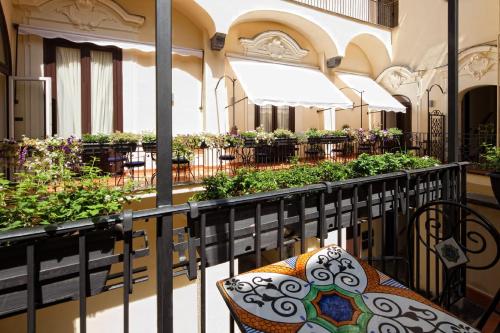 balcone con tavolo, sedie e piante di Maison Tofani a Sorrento