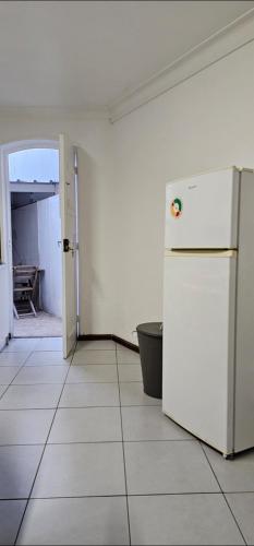 an empty kitchen with a white refrigerator in a room at Sé House View in Angra do Heroísmo