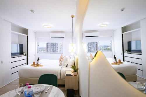 a hotel room with two beds and a table and chairs at Connect Studios by Vibrant in Lima