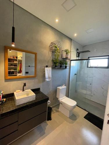 a bathroom with a toilet and a sink and a shower at Chácara de alto padrão in Água Boa