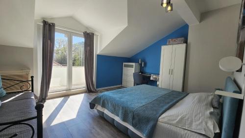 a bedroom with blue walls and a bed and a window at Adria Apartments and Rooms in Dubrovnik