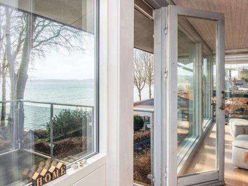 an open door to a balcony with a view of the ocean at 6 person holiday home in Bjert-By Traum in Bjert Strand
