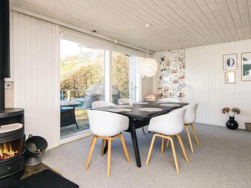 a dining room with a black table and white chairs at 6 person holiday home in Bjert-By Traum in Bjert Strand