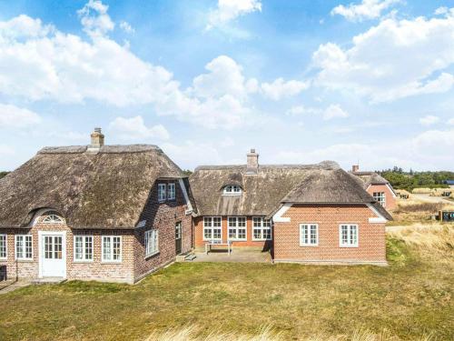 a large brick house with a thatched roof at 10 person holiday home in Blåvand in Blåvand