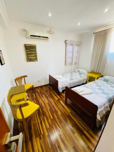 a room with two beds and a table and chairs at THE HEIRS Departamentos in Posadas