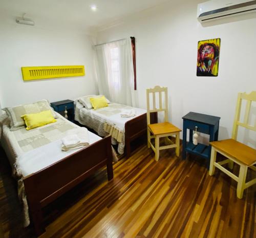 a room with two beds and a table and two chairs at THE HEIRS Departamentos in Posadas