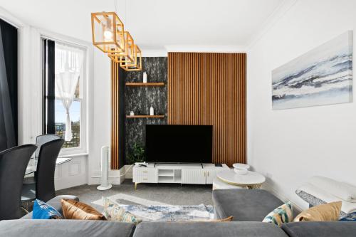 a living room with a couch and a tv at Bliss on the Bay in Eastbourne