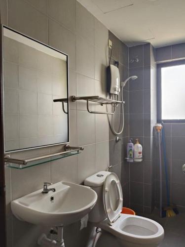 a bathroom with a sink and a toilet and a mirror at Pangkor L30 88 Corner villa House in Pangkor