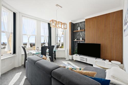 a living room with a couch and a tv at Bliss on the Bay in Eastbourne