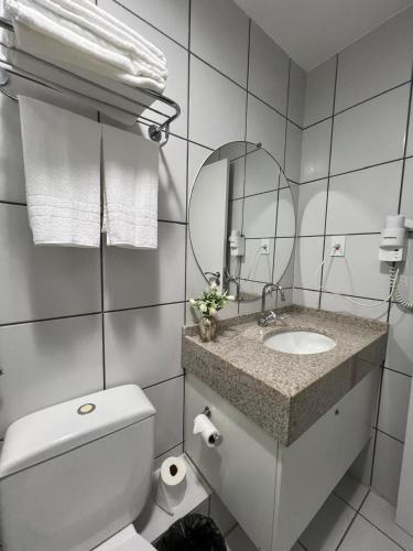 a bathroom with a toilet and a sink and a mirror at Gran Lençóis Flat Residence in Barreirinhas