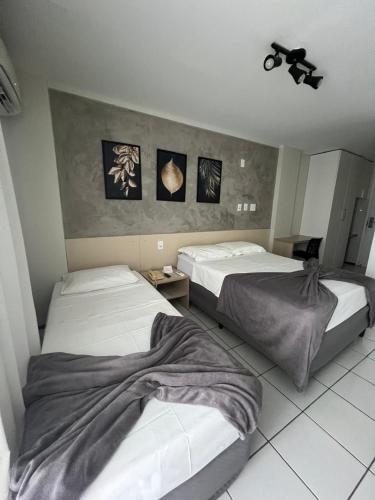 two beds in a hotel room at Gran Lençóis Flat Residence in Barreirinhas