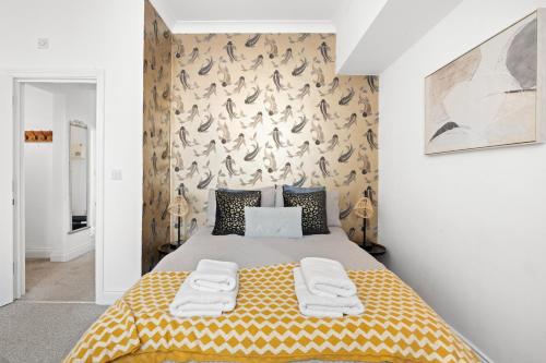 a bedroom with a large bed with a yellow blanket at Bliss on the Bay in Eastbourne
