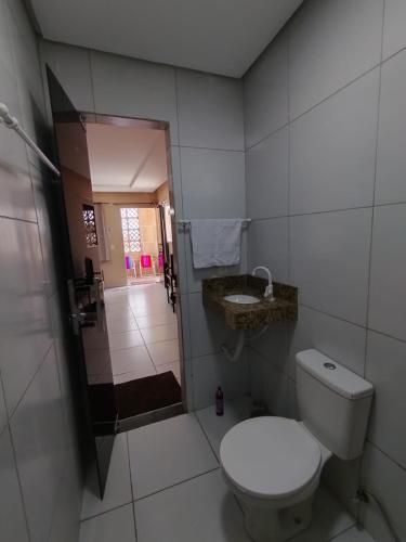 a white bathroom with a toilet and a shower at Kitnet 2 com varanda in Mossoró